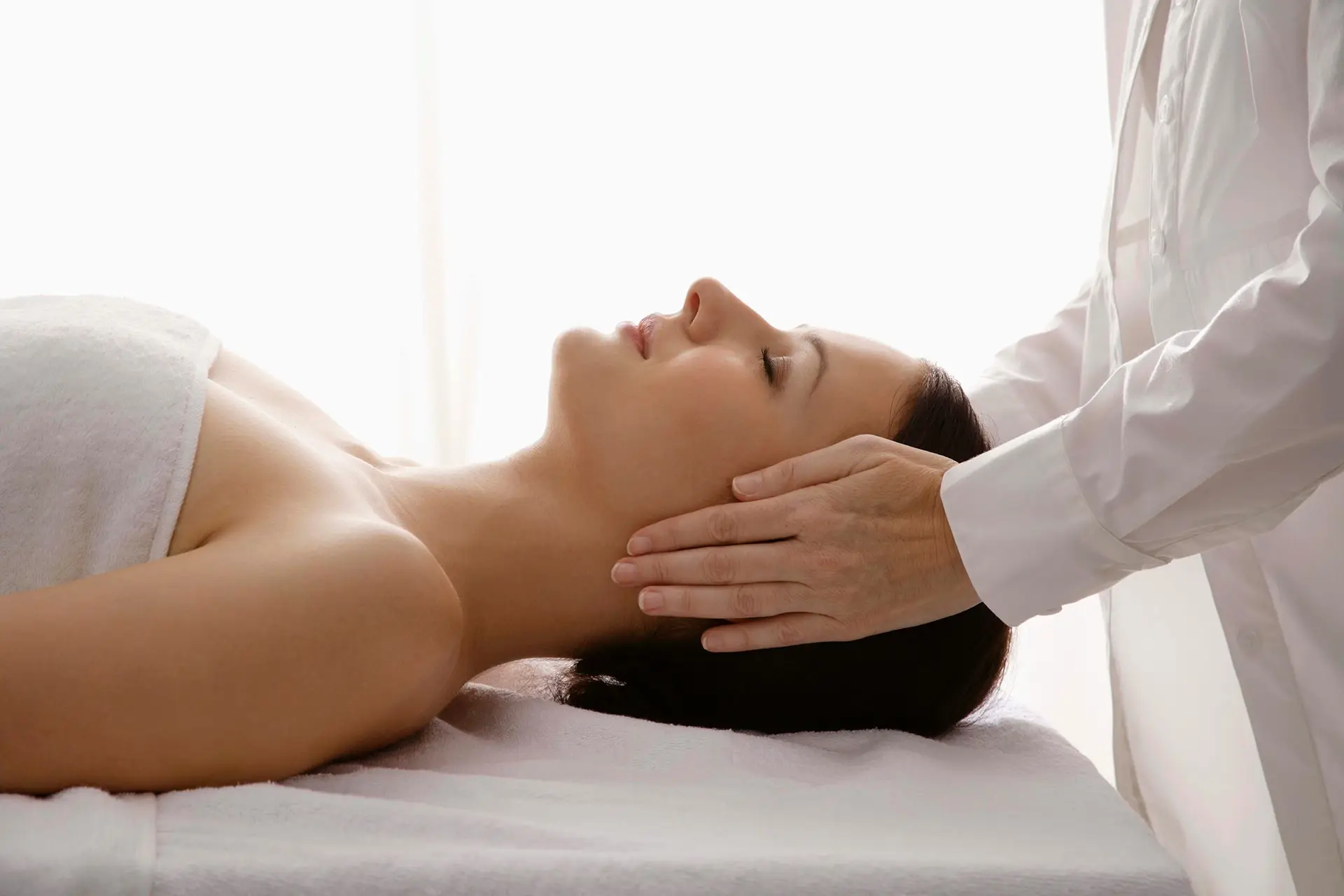 A woman receiving a Reiki treatment.